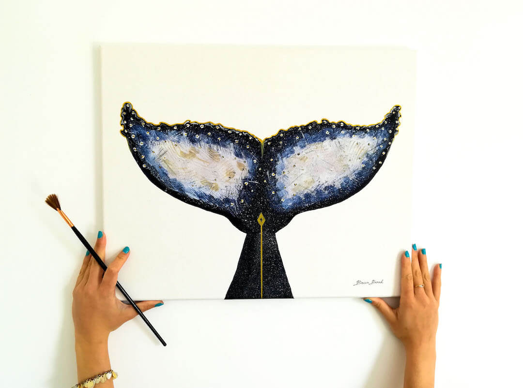 peinture acrylique sur toile de Becca Borah avec une queue de baleine avec des tons dorés et bleus